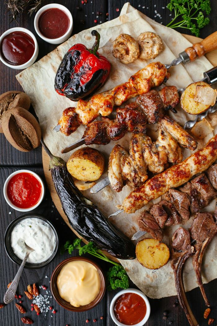 Brochetas de carne, pollo y verduras a la parrilla con pan de pita